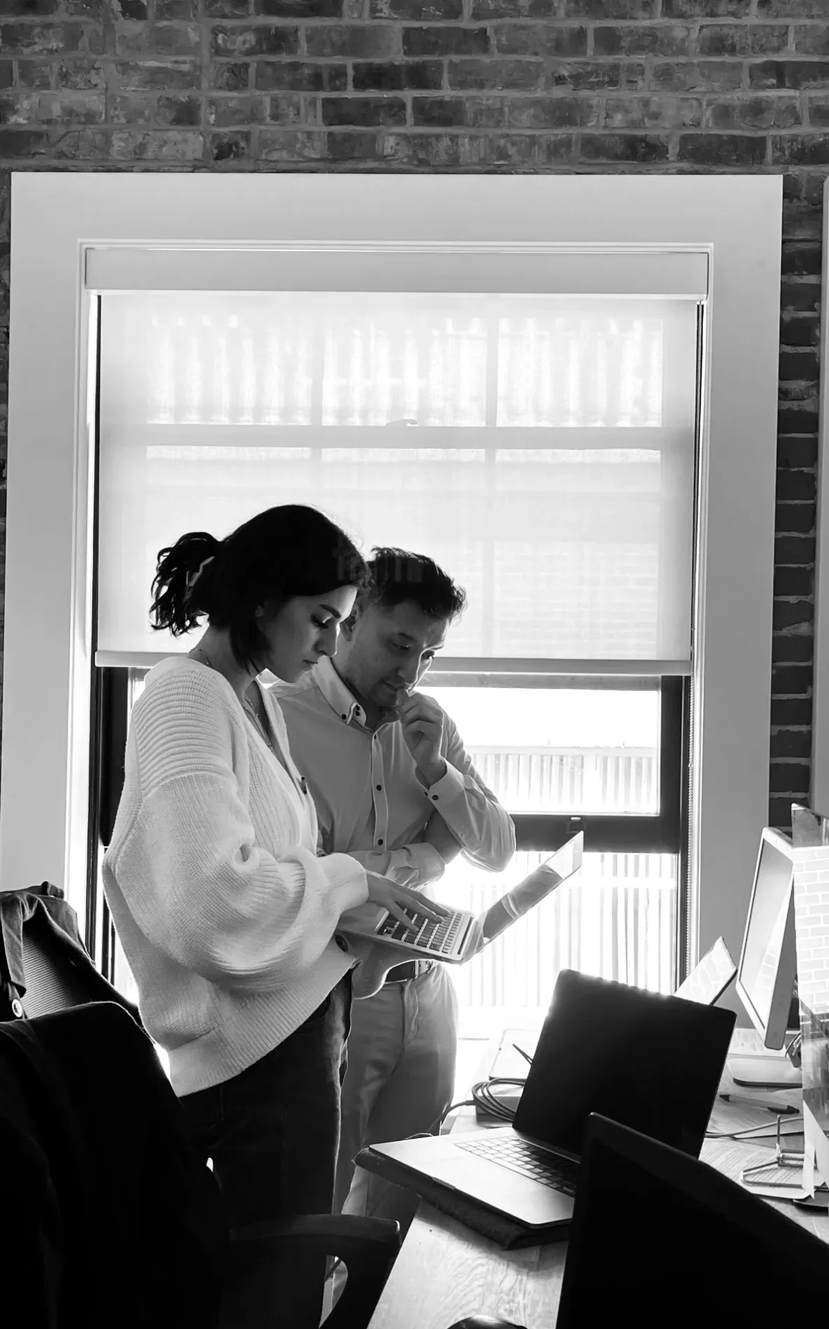 A huddle over the laptop by the windows