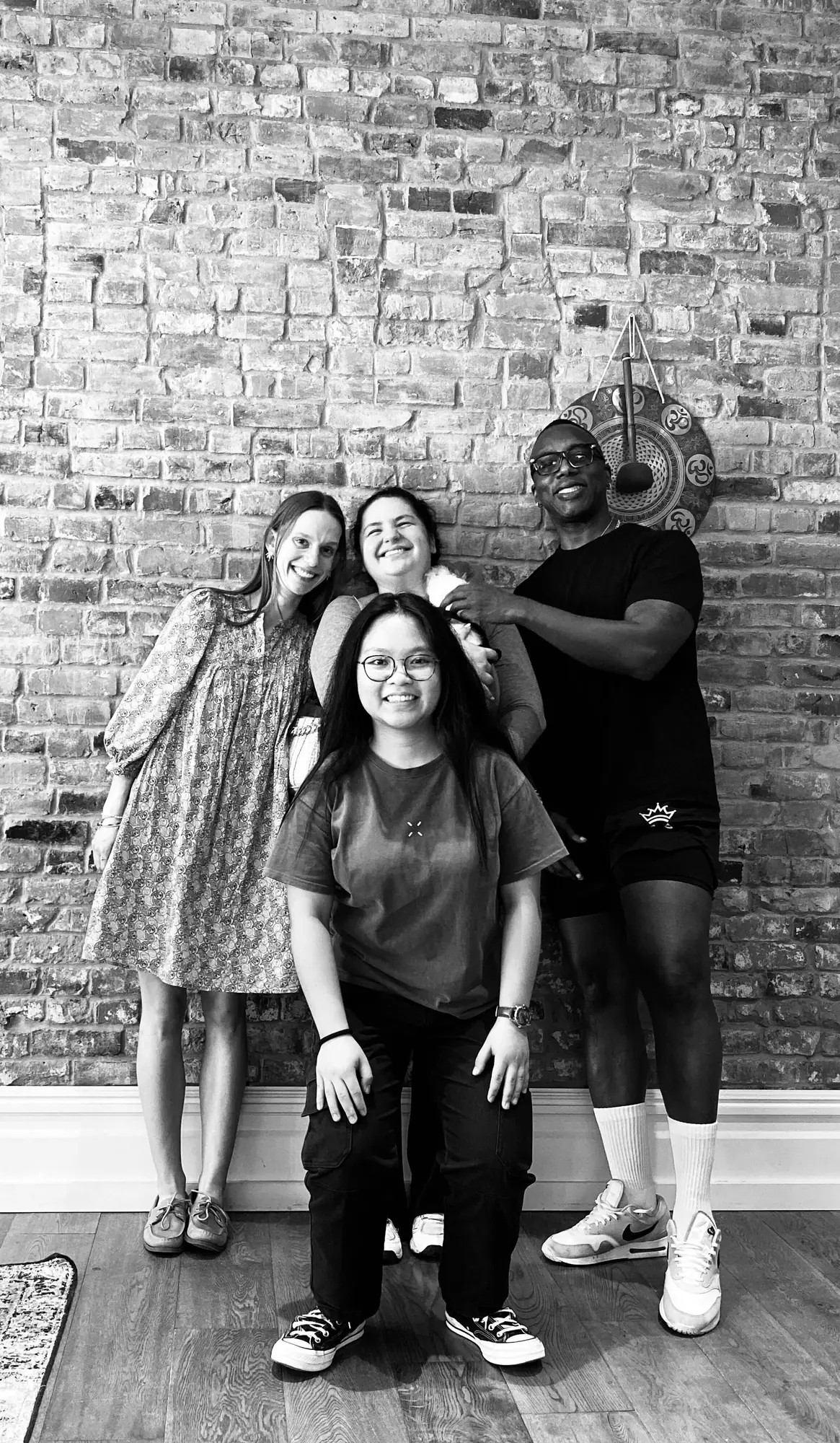 Four of the team together against the brick wall