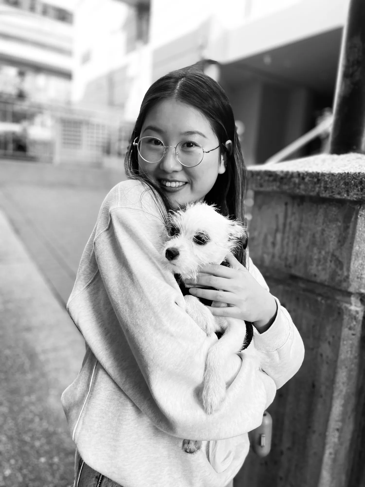 Holding a small white dog outside