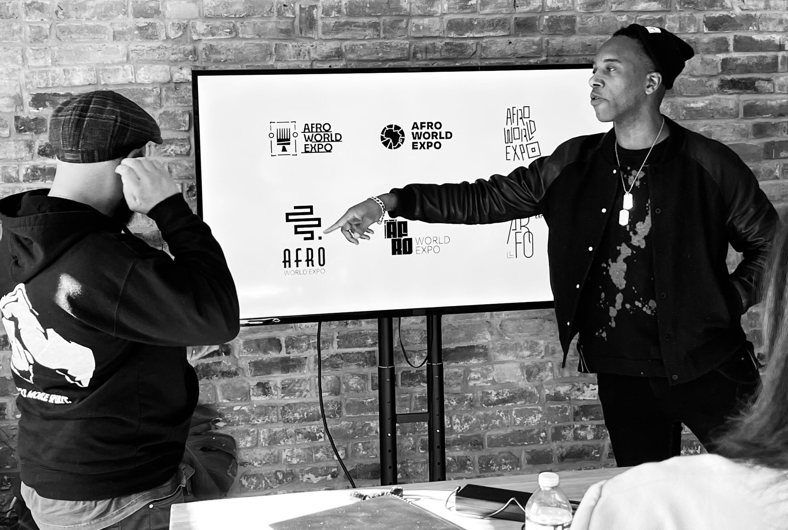 Team member pointing at a logo on the display screen during a meeting